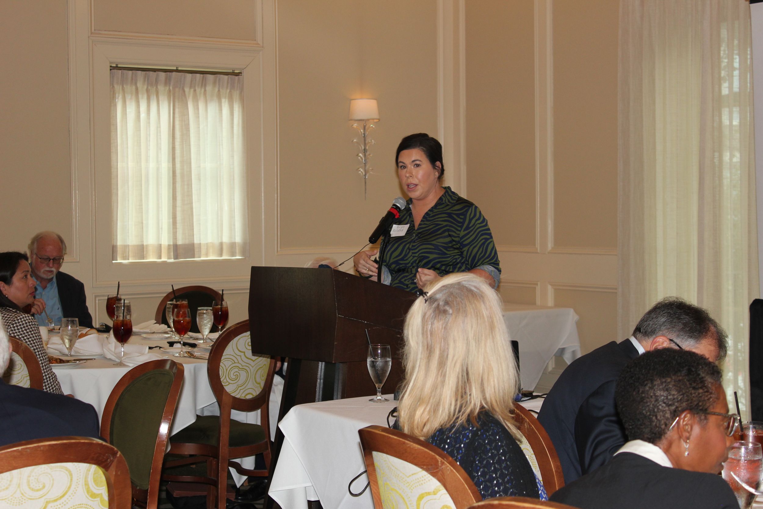 Attorney Bryn Poland speaks at a podium in front of a group of HBA members at a Senior Lawyers Forum on October 20, 2021